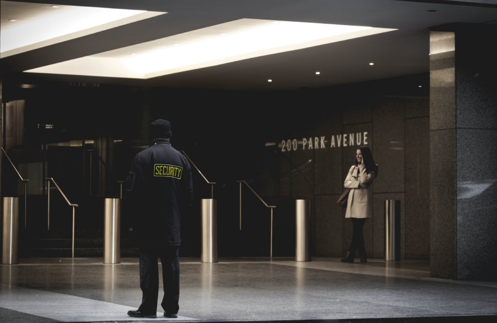 a man and woman standing in a large room with a sign on the wall